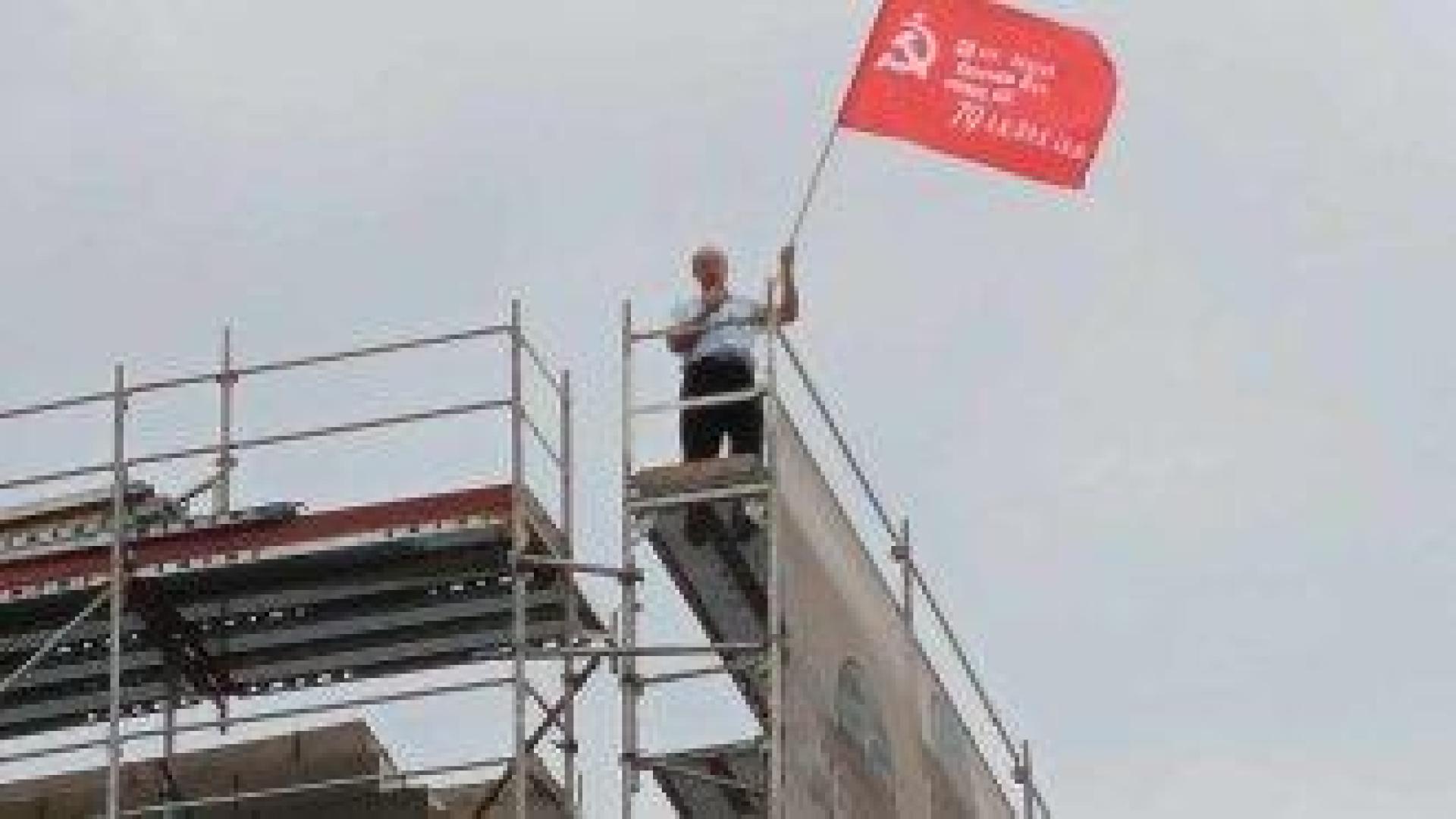 Марксист развя знаме със сърп и чук от скелето на МОЧА